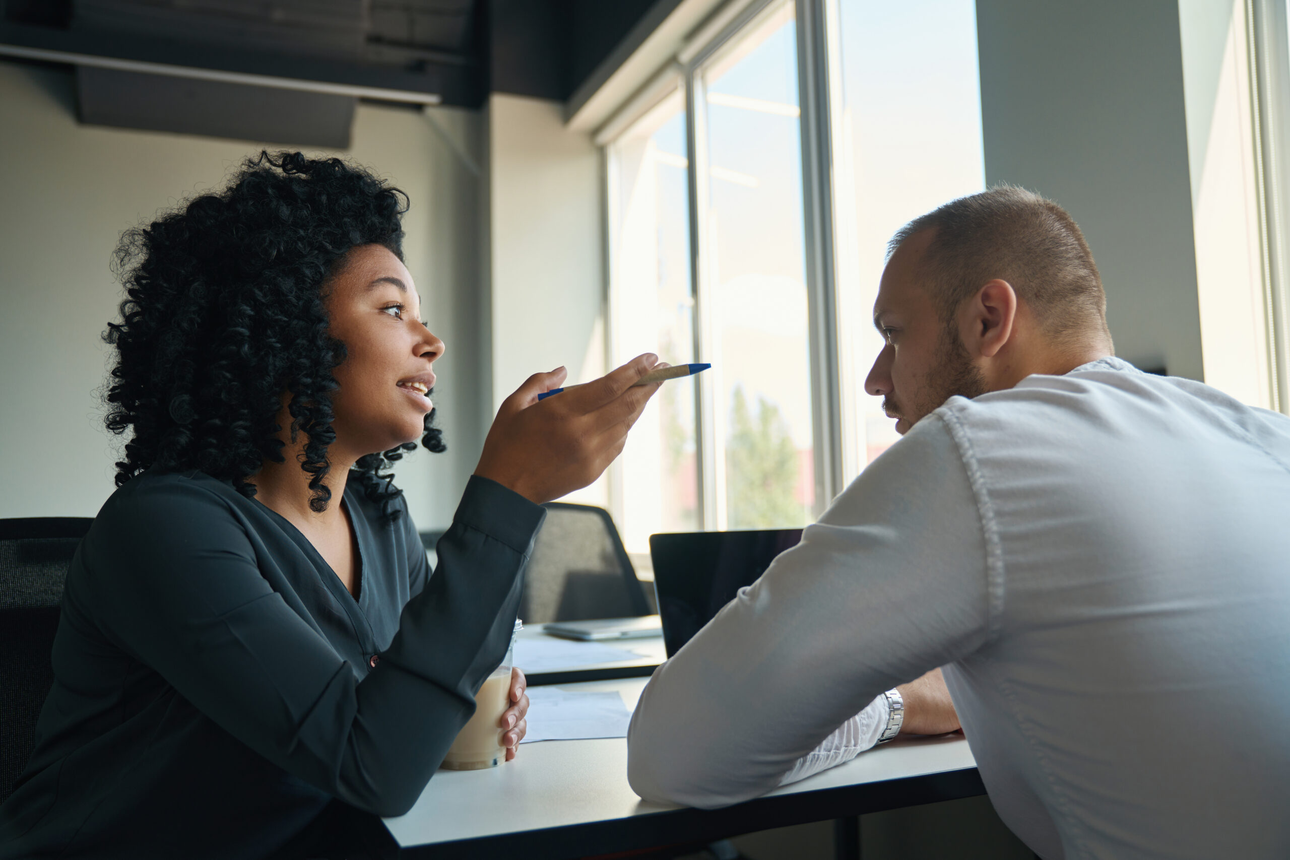 Employees Chatting At A Desk In A Simple Bright Office - Américo Contabilidade & Gestão Empresarial